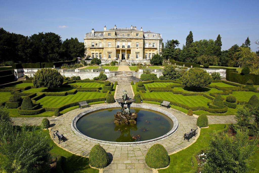 a large house with a fountain in the middle of a garden at Luton Hoo Hotel, Golf and Spa in Luton