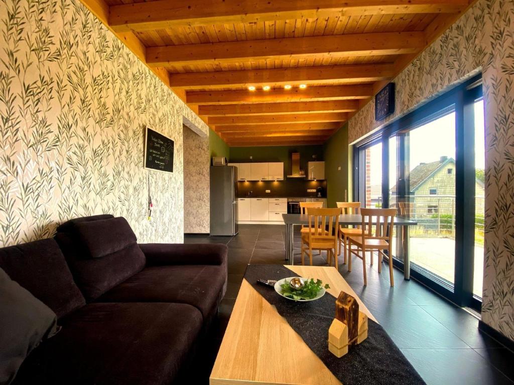 a living room with a couch and a table at Ferienwohnung am Weiher - Wohnung 8 - Für 4 Personen in Nideggen