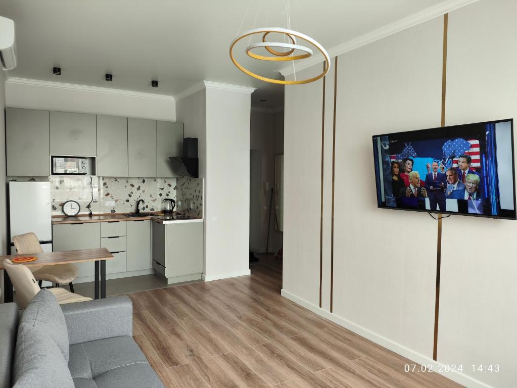 een woonkamer met een bank en een tafel en een keuken bij Tandau apartment in Taldykolʼ