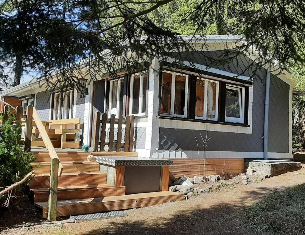 een tiny house met een veranda en een trap bij Waldhütte Allzunah in Ilmenau