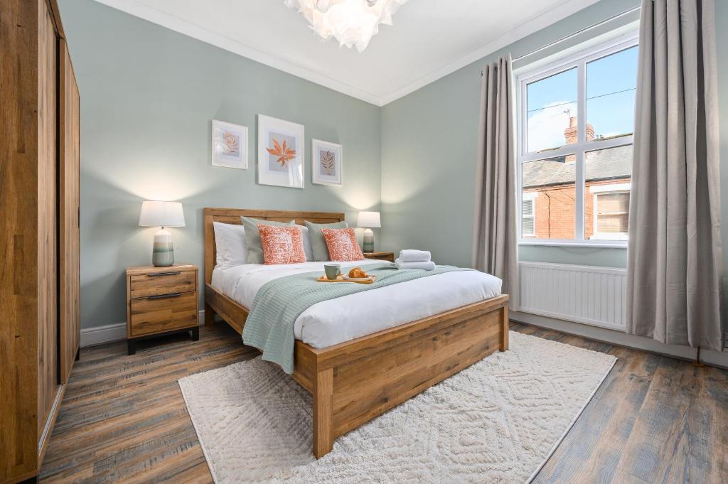 een slaapkamer met een groot bed en een raam bij 2-Bedroom Luxury Cottage - Long Stays in Cheadle