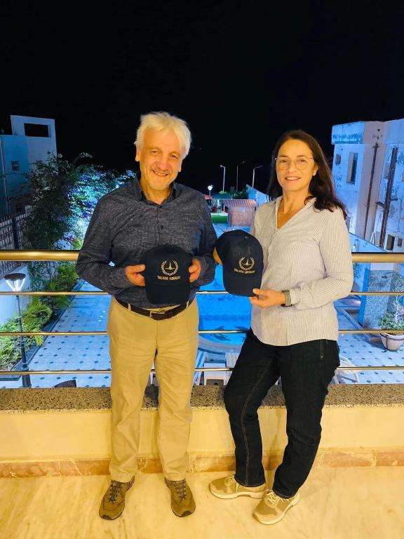 a man and a woman are holding hats at Tiba Rose hurghada in Hurghada