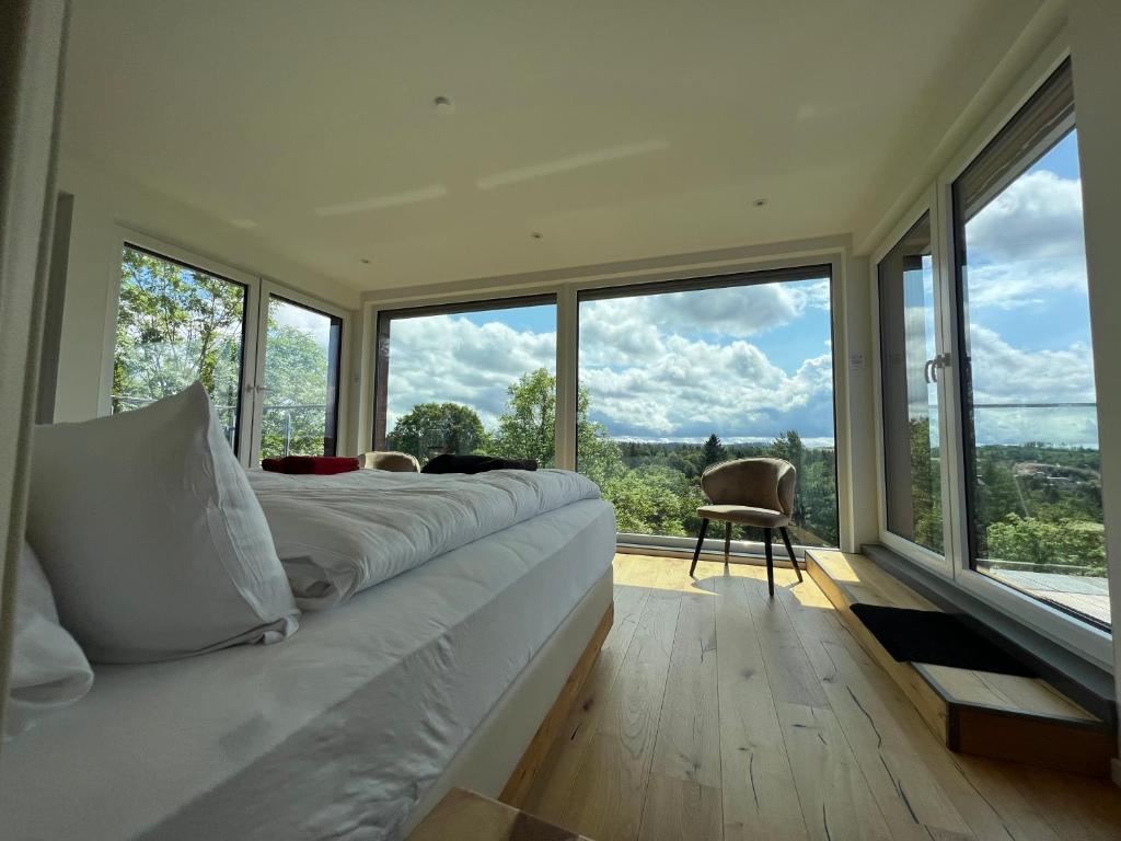 a bedroom with a large bed and large windows at Braunlage Lodge in Braunlage