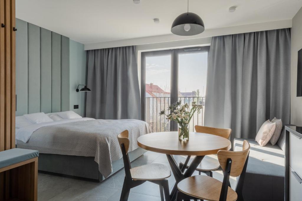 a hotel room with a bed and a table and chairs at AVAPARTS Apartament AQUA in Jastarnia