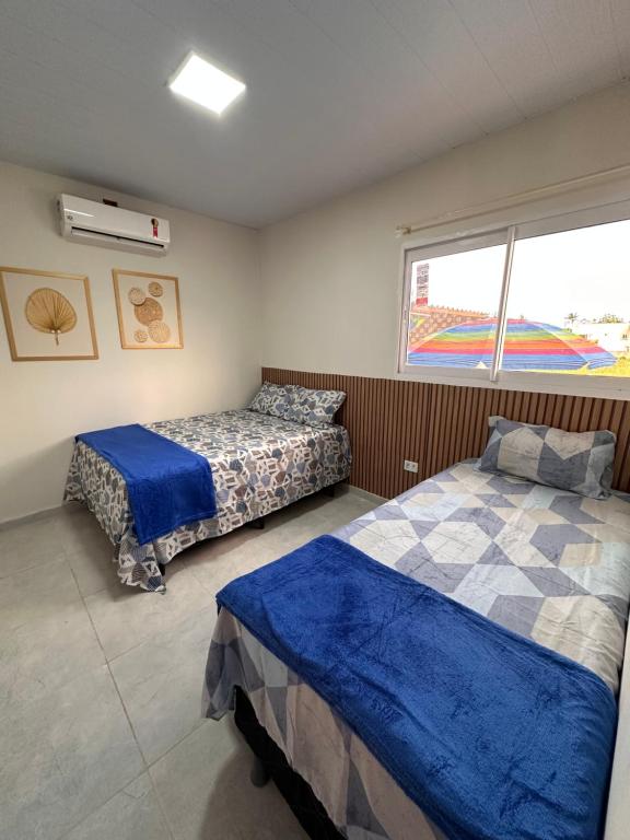 een slaapkamer met twee bedden en een raam bij Bela Beach in São José da Coroa Grande