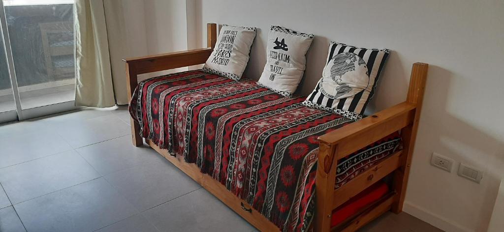1 dormitorio con cama con edredón y almohadas en Departamento Solares - San Martin en Bahía Blanca