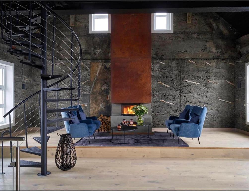 a lobby with blue chairs and a fire place at Lofoten Fyr in Værøy