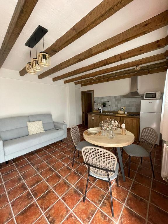 a kitchen and a living room with a table and chairs at El Capricho de la Serranía I in Tragacete