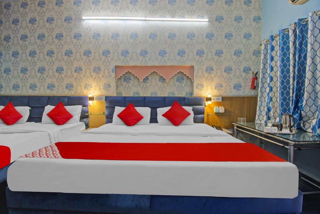 a bedroom with a large bed with red pillows at OYO Flagship Meenu Inn in Jaipur