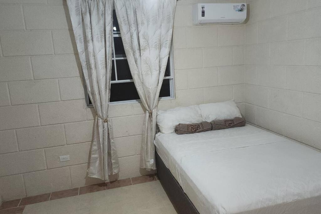 a small room with two beds and a window at Welcome to our 1 bedroom villa in Bridgetown