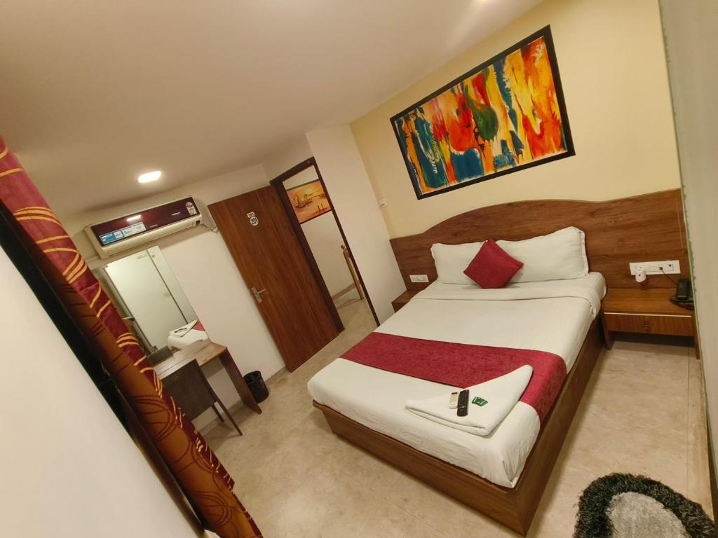 a bedroom with a large bed with a red blanket at Hotel Beach Crown Juhu in Mumbai