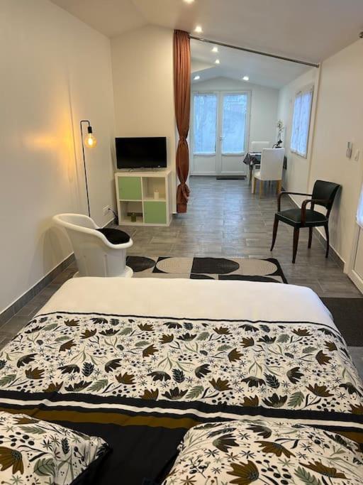 une chambre avec un lit et un salon dans l'établissement Trois Lilas ligne C, à Villeneuve-le-Roi