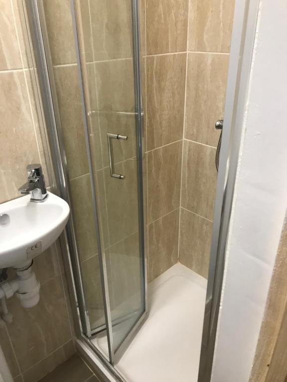 a shower with a glass door next to a sink at The Meadows in Marshfield