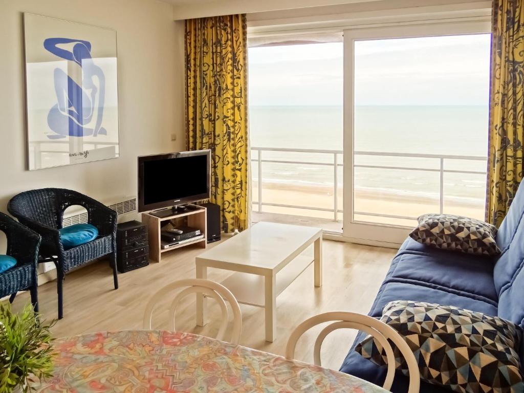 uma sala de estar com um sofá e uma televisão em Scorpio B1004 with beautiful sea views em Nieuwpoort