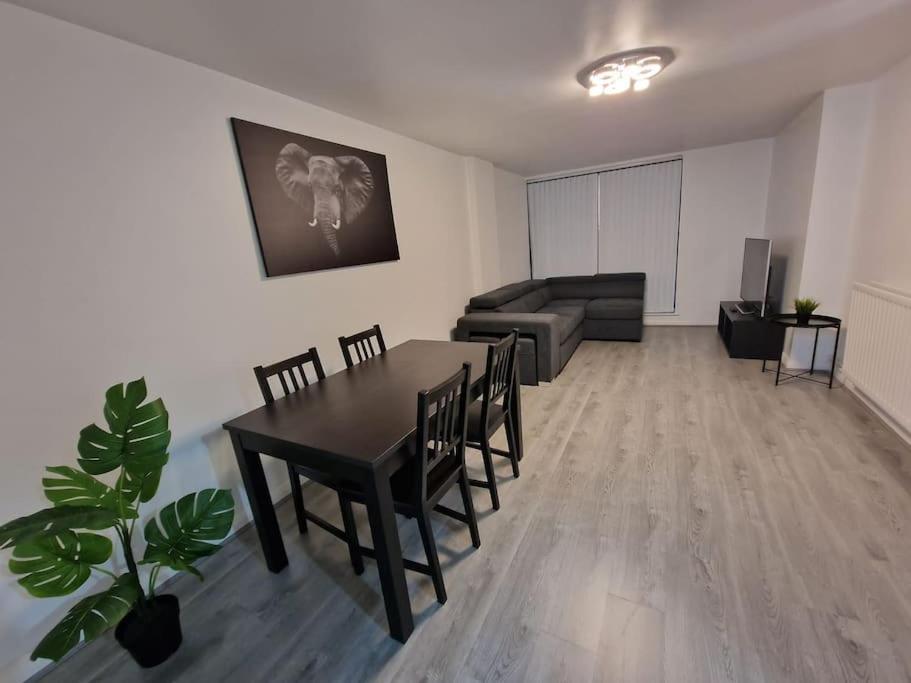 a living room with a table and chairs and a couch at Contemporary City Centre Flat in Belfast