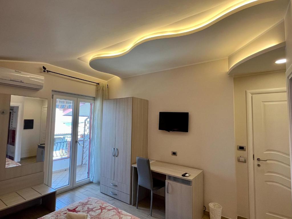 a room with a desk and a tv on a ceiling at B&B Galatea in Santa Domenica