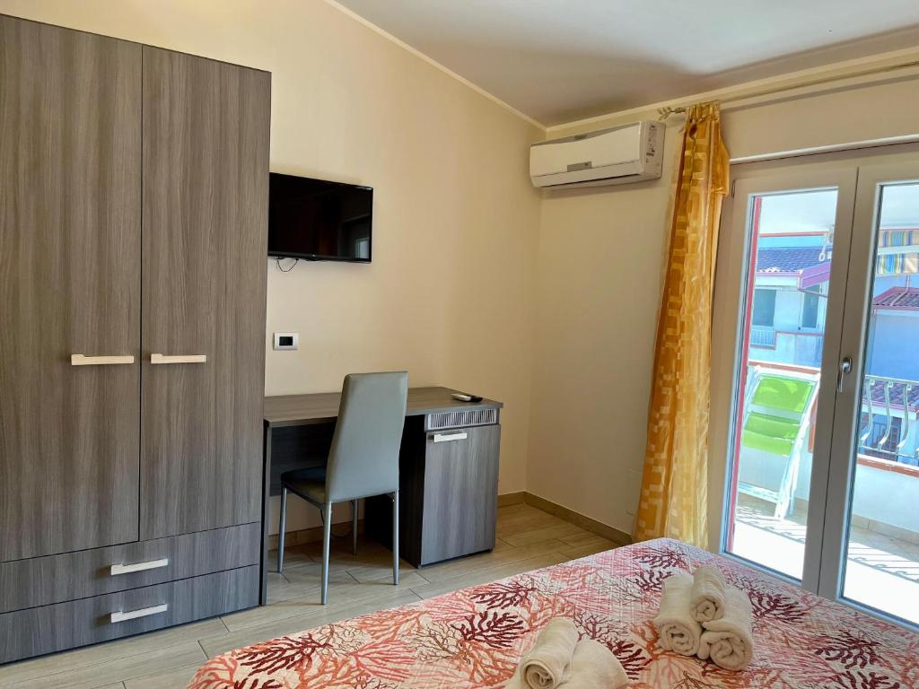 a bedroom with a bed and a desk with a computer at B&B Galatea in Santa Domenica