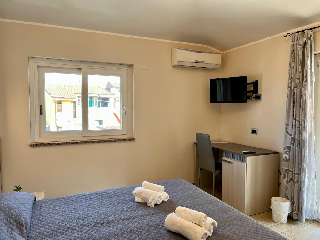 a bedroom with a bed and a window and a desk at B&B Galatea in Santa Domenica