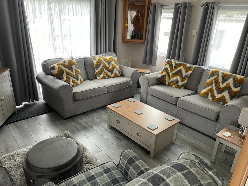 a living room with two couches and a coffee table at Luxury modern caravan Seton Sands in Port Seton