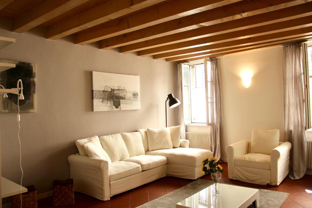sala de estar con sofá blanco y silla en [Centro storico] deluxe flat, en Udine