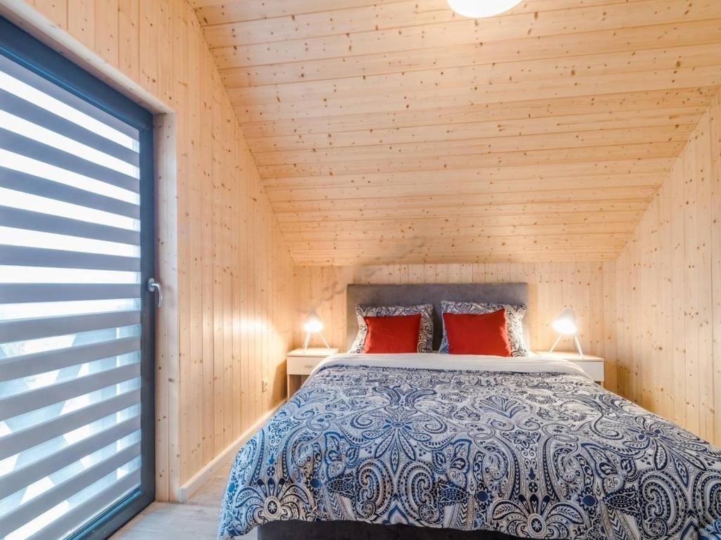 a bedroom with a bed in a wooden cabin at Domki Kasjopeja in Władysławowo