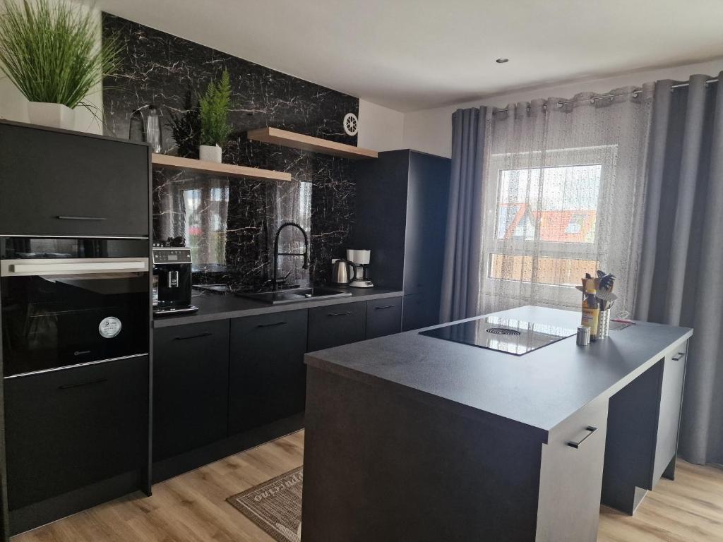 a kitchen with black cabinets and a black counter top at Ferienwohnung Engel in Grebenstein