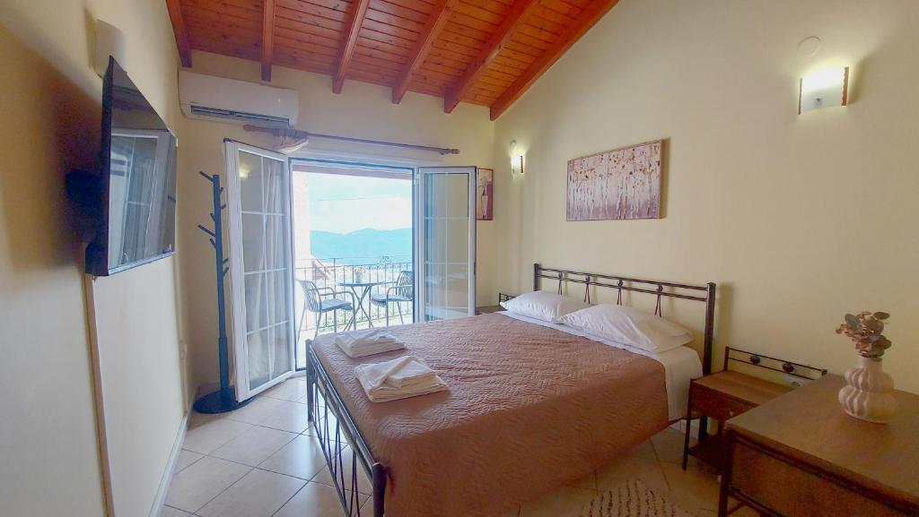 a bedroom with a bed with a view of a balcony at Traditional Mount Retreat - Ano Pavliana - Corfu in Áno Pavliána