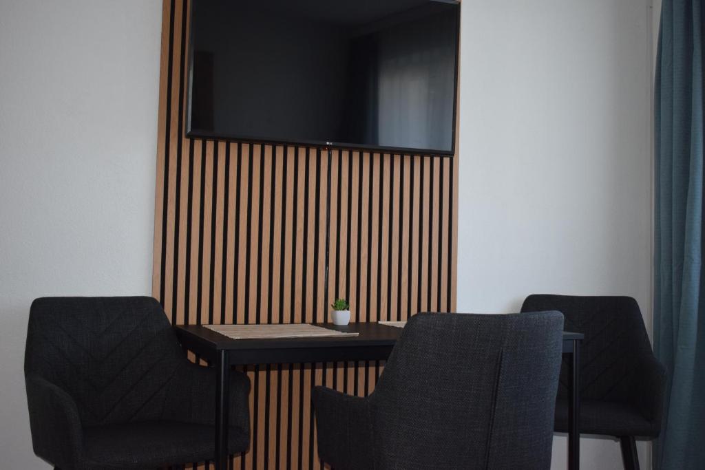 a table with two chairs and a television on a wall at Alpha Alpin Apartment in Zell am See