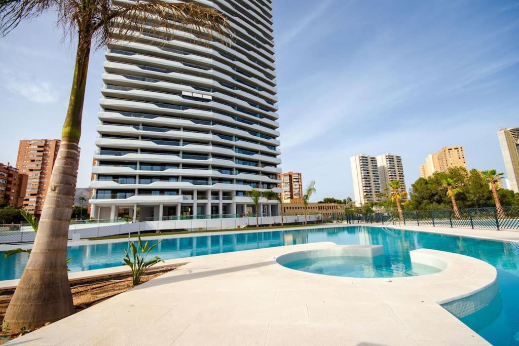 una piscina di fronte a un edificio alto di Benidorm Beach Luxury 046 a Benidorm