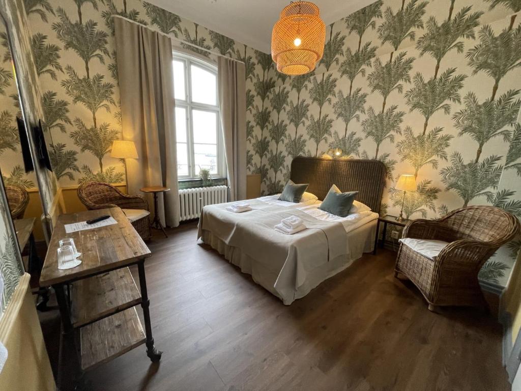 sypialnia z łóżkiem, stołem i krzesłami w obiekcie Stationen w mieście Ystad