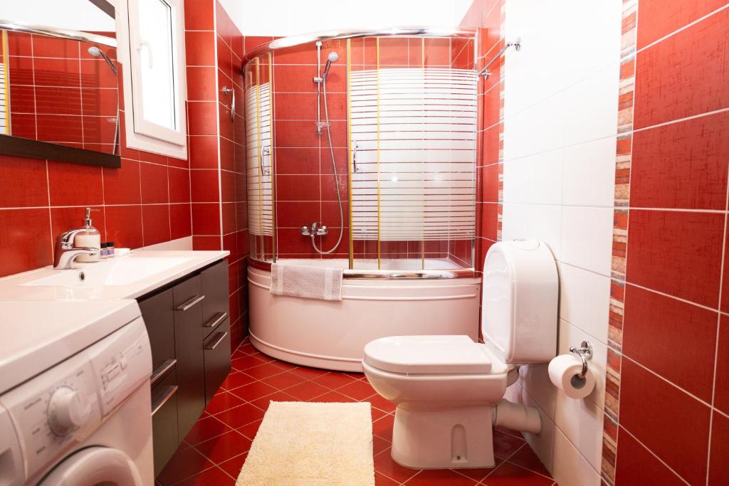 a red bathroom with a toilet and a sink at Villas Gregory in Syvota