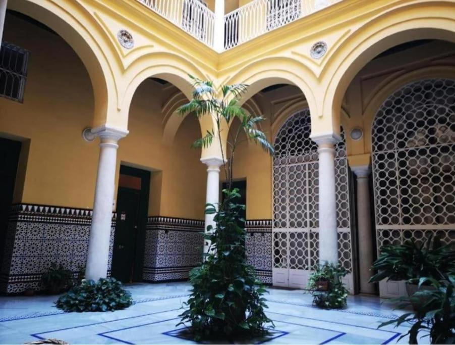 un edificio con palmeras en un patio en Conteros Centro Apartment, en Sevilla
