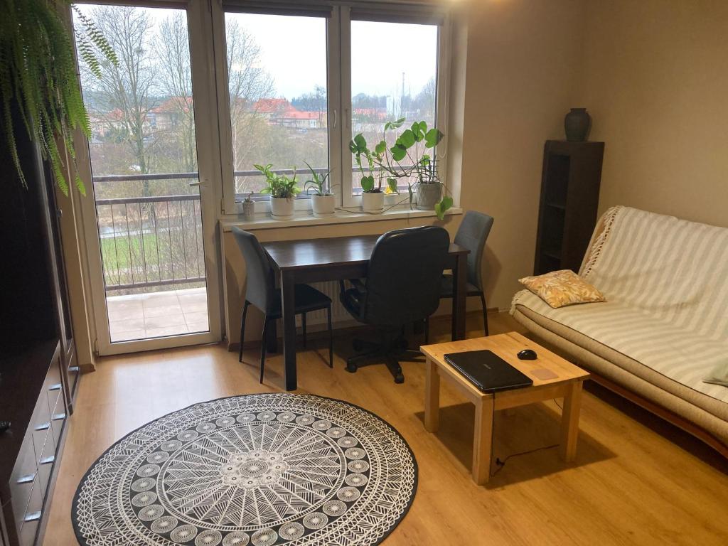 sala de estar con mesa y sofá en Apartament nad rzeką na Mazurach, en Olecko