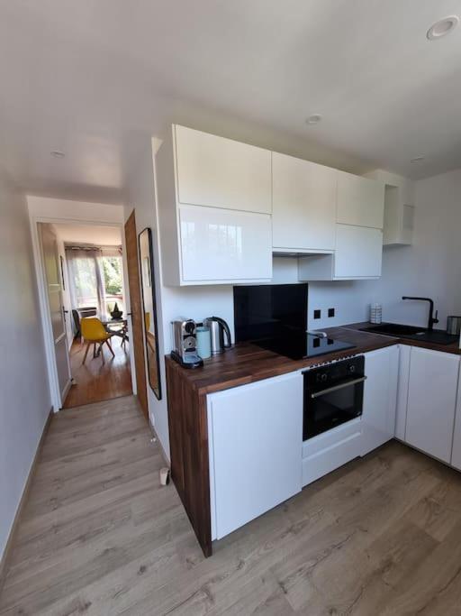 une cuisine avec des armoires blanches et un plancher en bois dans l'établissement Appartement , 6 personnes, centre-ville, plage à pied, à Saint-Jean-de-Luz