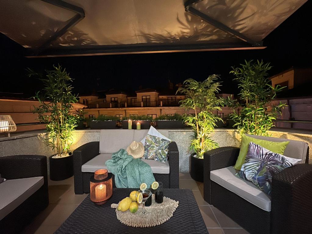 a patio with two couches and a table with fruits at Ático Luz y Mar in Cambados