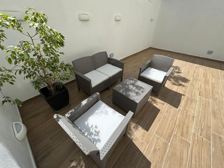 sala de estar con 2 sillas y sofá en Marsaxlokk Modern Apartment, Large Backyard, en Marsaxlokk
