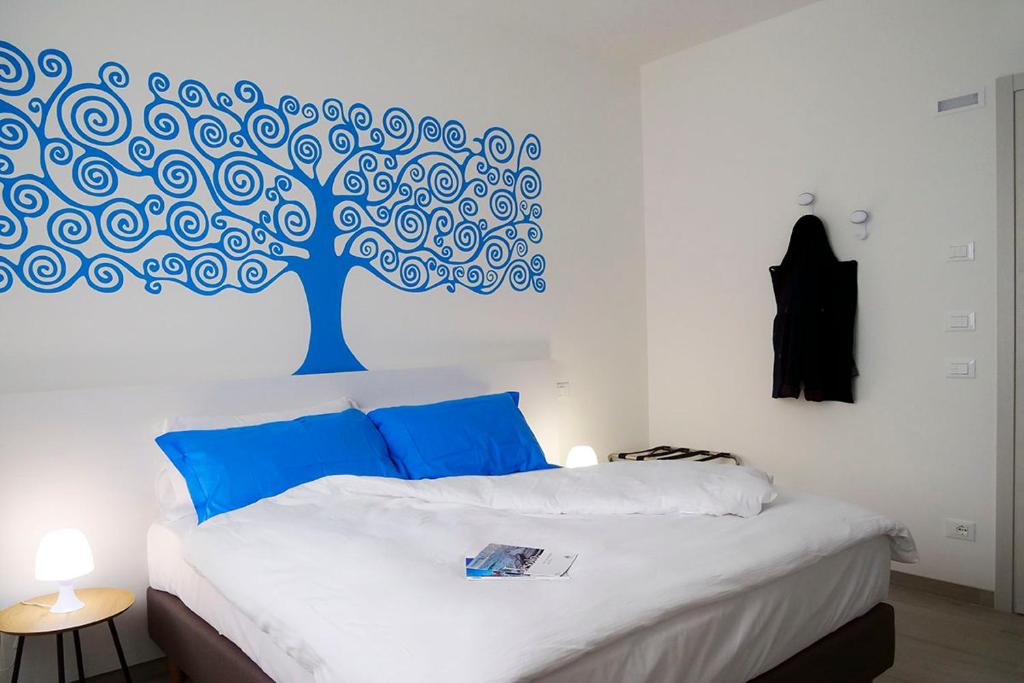 利多迪迪耶索洛的住宿－Casadamare，卧室的墙上挂着蓝色的树壁画