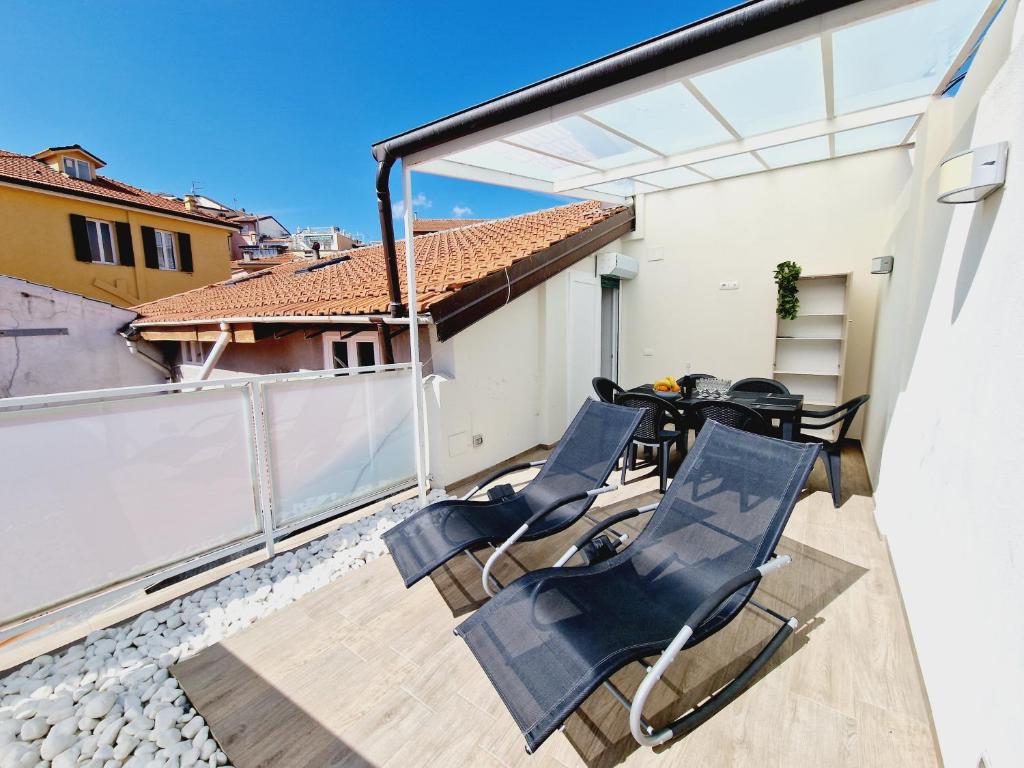 - un balcon avec des chaises et une table dans un bâtiment dans l'établissement HomeHoliday LUXE - MY PLACE SANREMO, à Sanremo