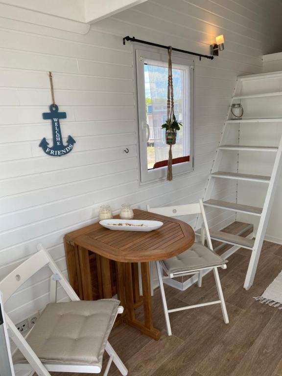 una sala da pranzo con tavolo, sedie e scala di Tiny House am Meer a Heringsdorf
