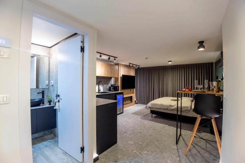a room with a kitchen and a bedroom with a bed at Urbano in Haifa