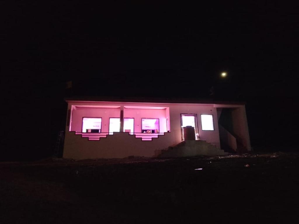 uma casa com luzes cor-de-rosa à noite em Saisagar beach resort em Devgarh