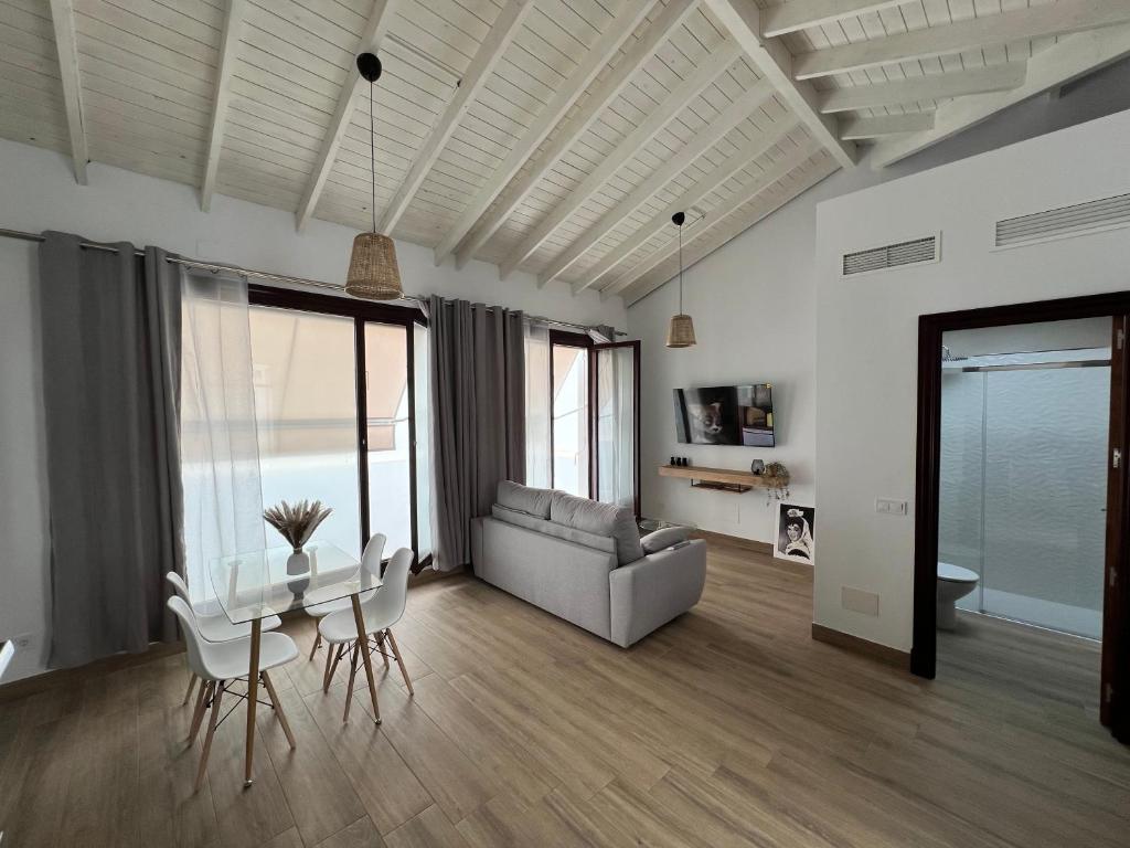 a living room with a couch and a table and chairs at M&M Empedrada Apartamentos Jerez in Jerez de la Frontera
