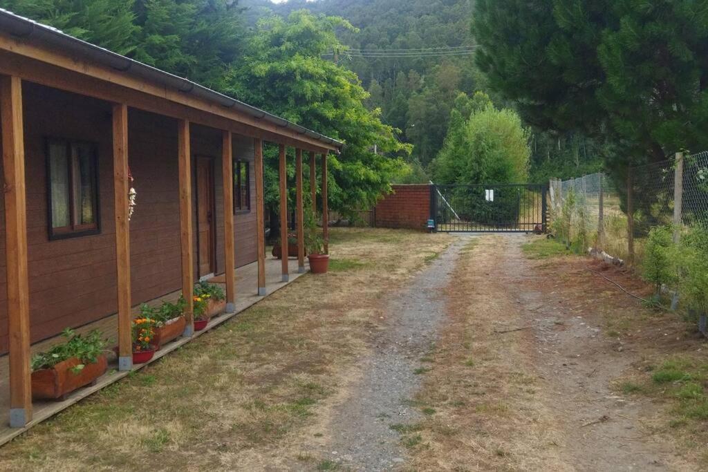 瓦爾迪維亞的住宿－Chalet Valdivia，一条土路,靠近一座带栅栏的房子