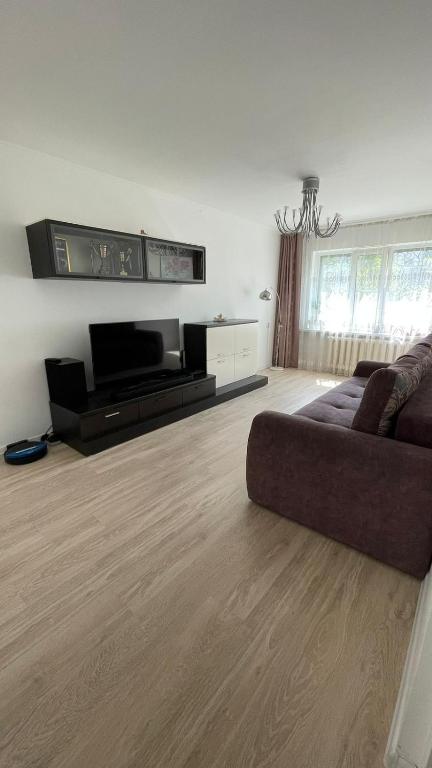 ein Wohnzimmer mit Couch und Flachbildfernseher in der Unterkunft Квартира между правым и левым берегом, рядом с набережной на улице Габдуллина in Astana