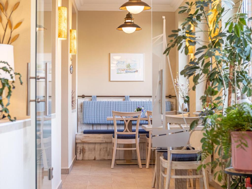 un restaurante con mesas, sillas y plantas en Hotel Stone en Zingst