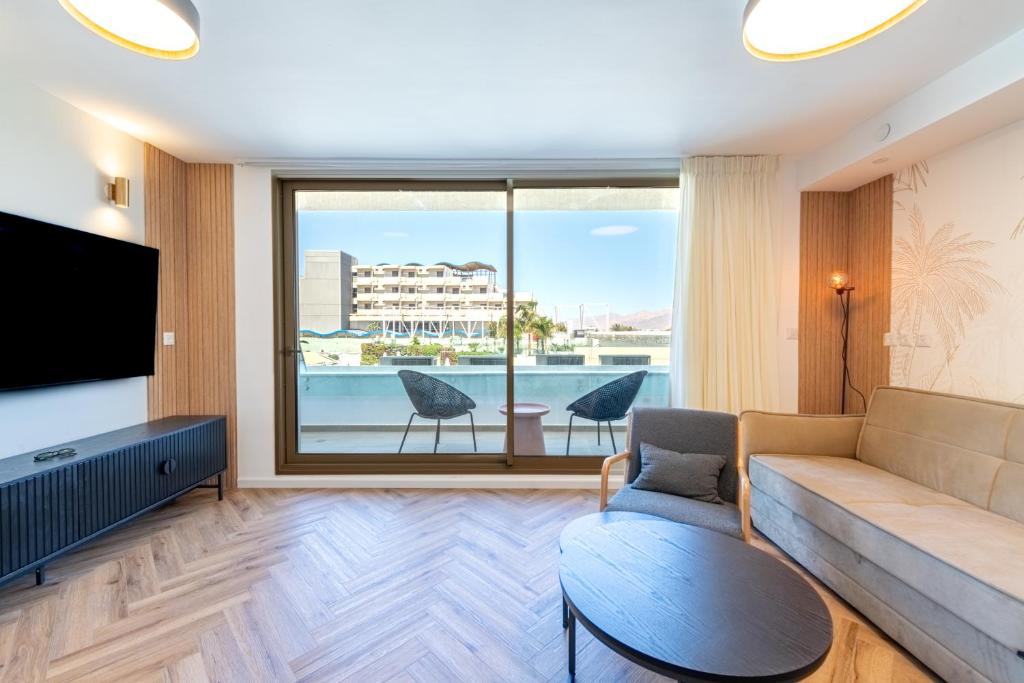 - un salon avec un canapé et une grande fenêtre dans l'établissement Sea View Coral - City Center Amazing Pool, à Eilat