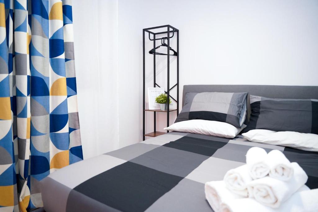 a bedroom with a bed with a checkered curtain at Splendido Monolocale A Roma in Casale Smeraldi