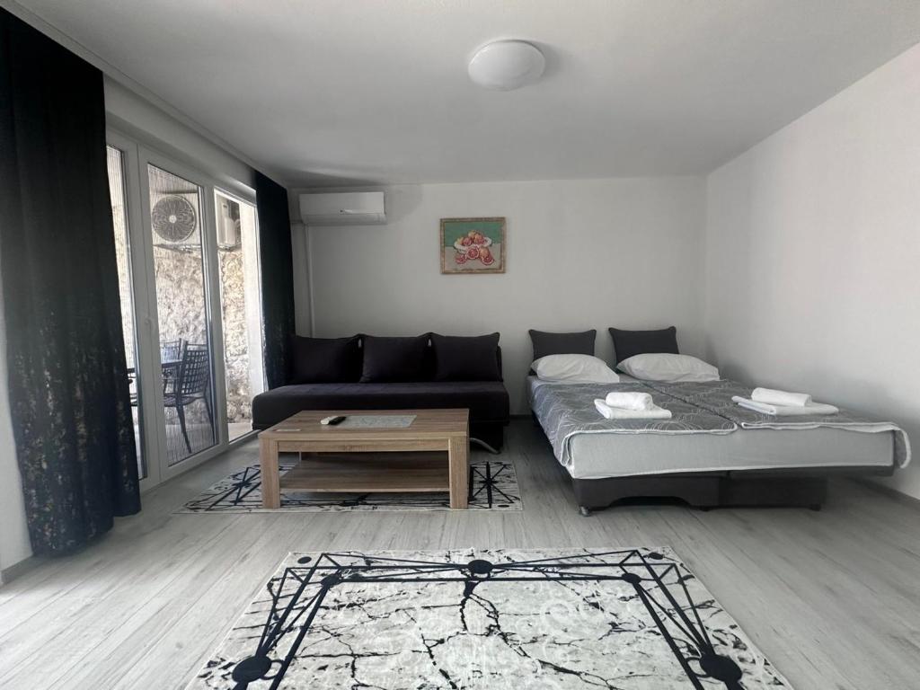 uma sala de estar com um sofá e uma mesa em Cuprija _apartments em Stolac