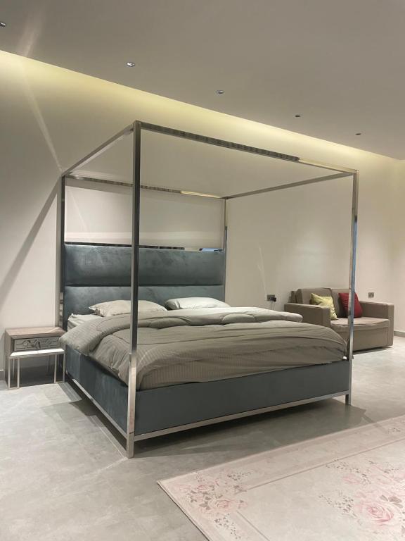 1 dormitorio con 1 cama grande con marco de metal en النوف فيلا en Murayjāt