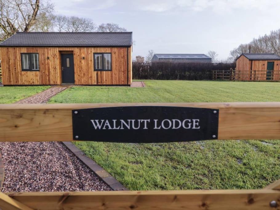 a sign on a fence in front of a building at Walnut Lodge in Ashbourne